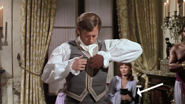 Swashbuckler - long haired black cat held by a woman in background while Major Folly Beau Bridges removes shirt