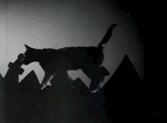 The Telltale Heart - black cat walking across surreal cityscape right to left