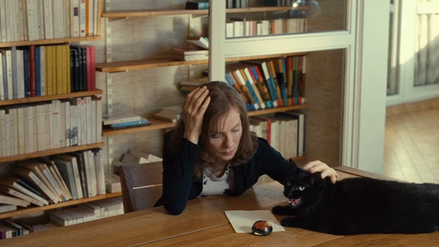 Things to Come - black cat Pandora on table beside Nathalie Isabelle Huppert