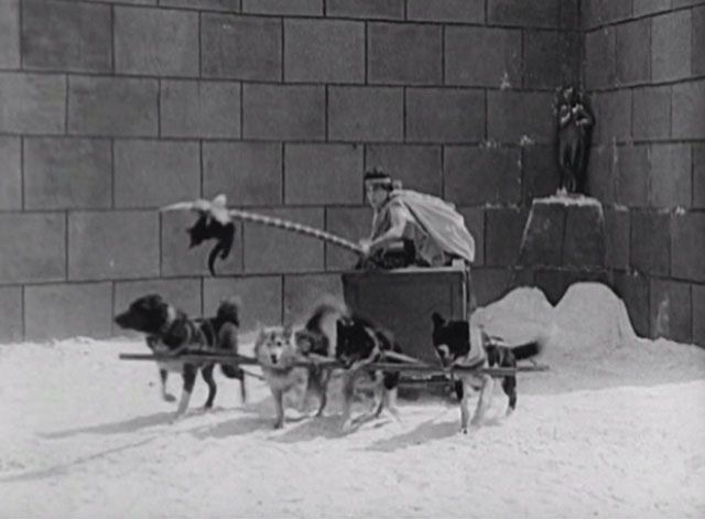 Three Ages - Buster Keaton dangles black cat from spear in front of dog team