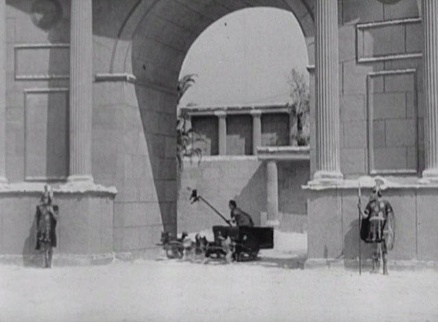 Three Ages - Buster Keaton dangles black cat from spear in front of dog team