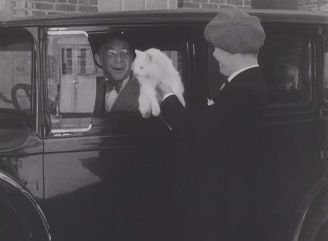 Torchy's Kitty Coup - Torchy Ray Cooke holding up longhair white cat to Franklin Pangborn