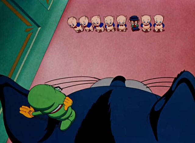 Toy Trouble - cartoon blue and white cat with Bookworm on head looking down at Sniffles mouse in line of Porky Pig dolls