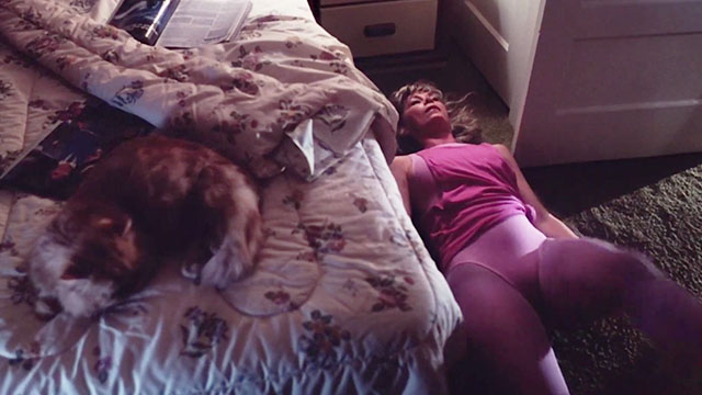 Trick or Treat - longhair ginger tabby cat lying on bed with Angie Elaine Joyce exercising on floor