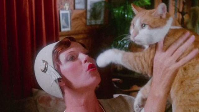 The Uncanny - ginger and white tabby cat Scat being held up by Edina Samantha Eggar