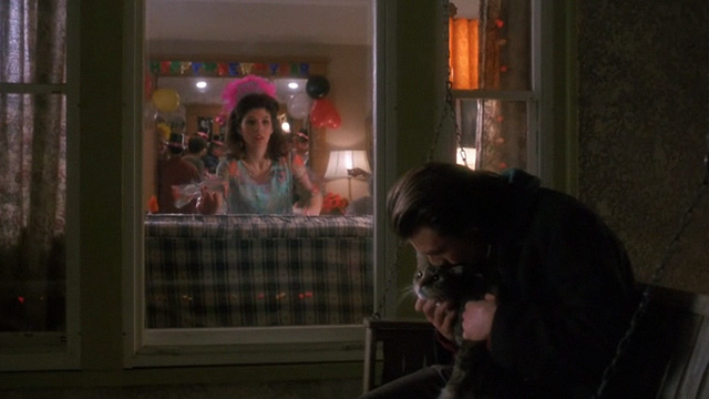 Untamed Heart - Caroline Marisa Tomei looking out window at Adam Christian Slater holding tabby cat on porch swing