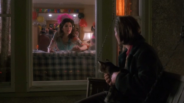 Untamed Heart - Caroline Marisa Tomei looking out window at Adam Christian Slater holding tabby cat on porch swing