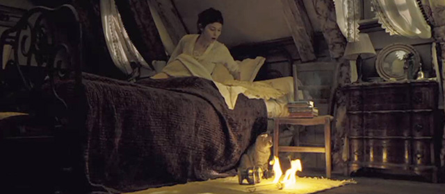 A Very Long Engagement - tabby cat next to burning oil lamp on floor next to bed with Mathilde Audrey Tautou