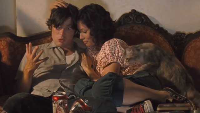 Watching the Detectives - Neil Cillian Murphy and Violet Lucy Liu sitting on couch with longhair pastel calico cat