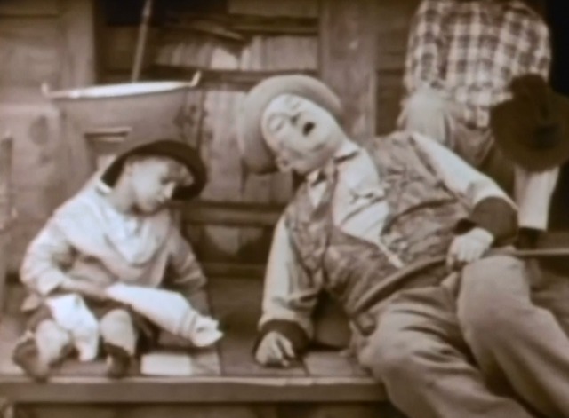 Way Down East - white kitten sleeping between sleeping boy's legs