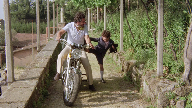The Weapon, the Hour, the Motive - L'arma l'ora il movente - Ferruccio Arturo Trina holding black kitten while climbing onto motorcycle with Inspector Boito Renzo Montagnani
