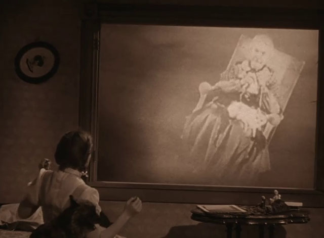 The Wizard of Oz - Dorothy Judy Garland looking at old woman knitting in rocking chair with cat in lap outside window in tornado