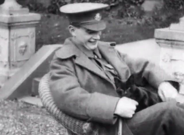 Wounded Soldier - young British officer sitting in chair petting black cat