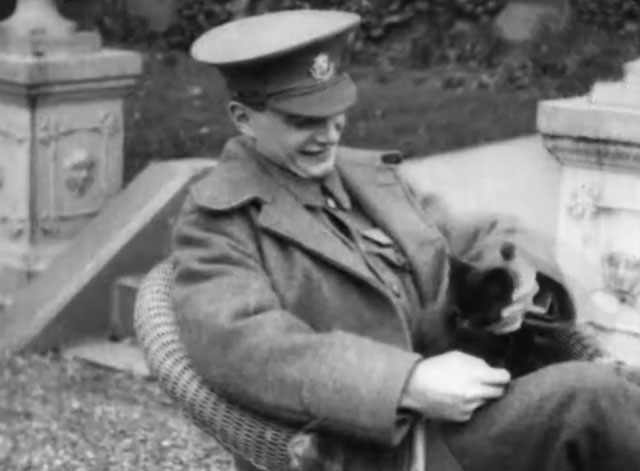 Wounded Soldier - young British officer sitting in chair petting black cat