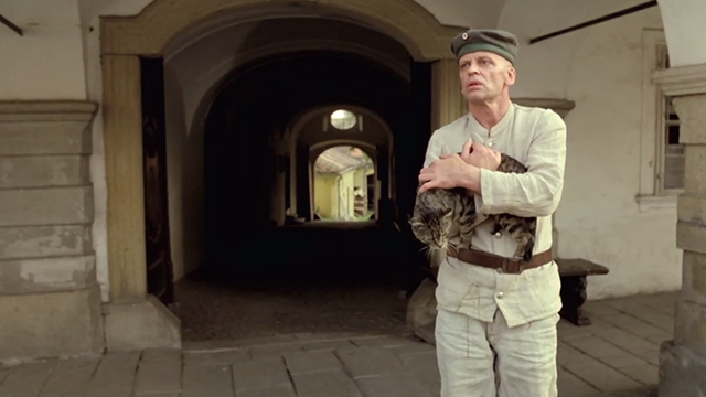 Woyzeck - Klaus Kinski holding tabby cat in front of building
