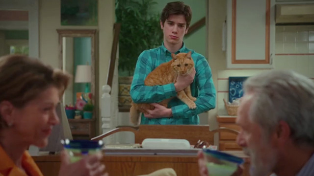 American Housewife - Grandma's Way - Oliver Daniel DiMaggio holding ginger tabby cat Mittens behind Kathryn Wendie Malick and Dan Gregory Harrison