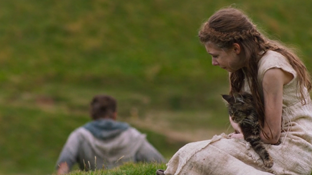 Britannia - Episode #1.1 - Cait Eleanor Worthington-Cox holding long-haired tabby cat while Divis Nikolaj Lie Kaas walks away