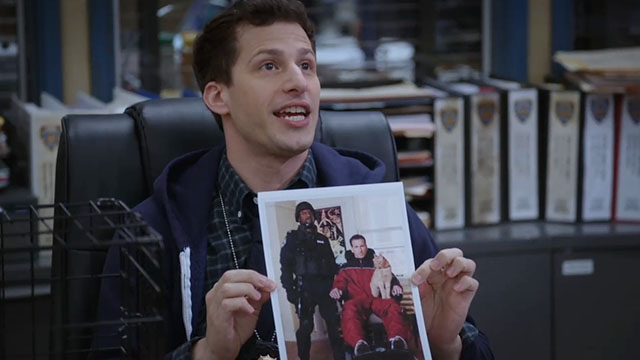 Brooklyn Nine-Nine - Terry Kitties - Peralta Andy Samberg holding up photo of Terry Crews with Dimitri Kuzkho Andrew Oilveri and red tabby cat