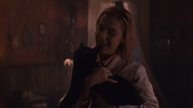 The Chilling Adventures of Sabrina - October Country - Sabrina Kiernan Shipka holding black cat Salem