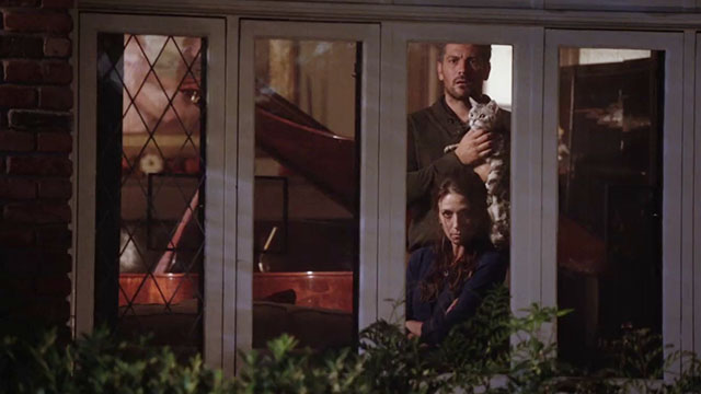 Don't Trust the B---- in Apartment 23 - It's a Miracle - Marin Hickle with Michael Landes holding tabby cat Freckles looking out window
