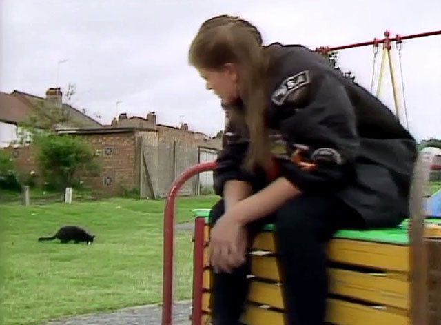 Doctor Who - Survival - Ace Sophie Aldred looking at black cat Kitling in park