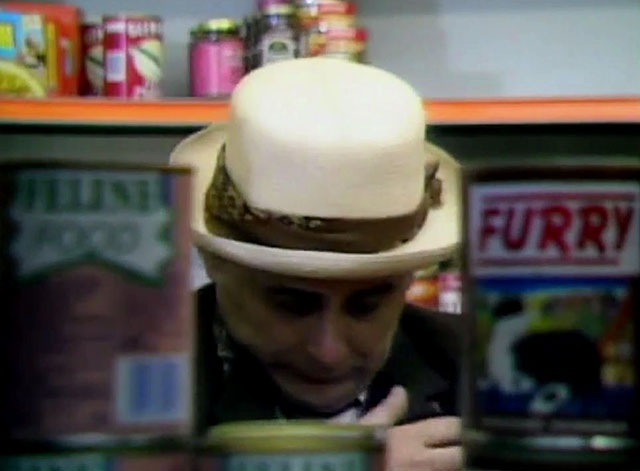 Doctor Who - Survival - Dr. Who Sylvester McCoy standing behind Furry cat food cans