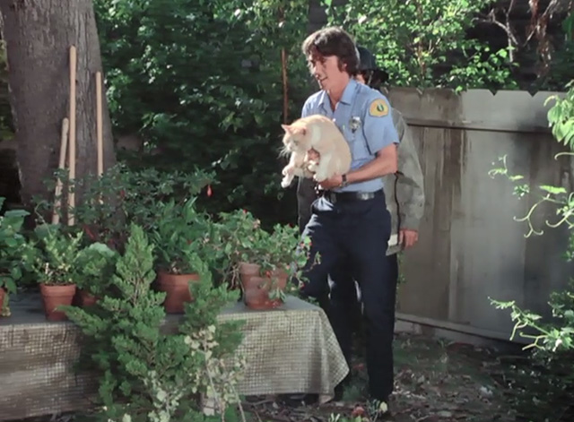 Emergency - The Unlikely Heirs - John Randolph Mantooth carrying orange and white cat Simba across yard