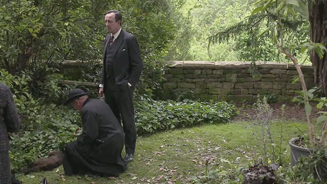 Father Brown - The Wrong Shape - Mark Williams squatting over body of dead tortoiseshell cat