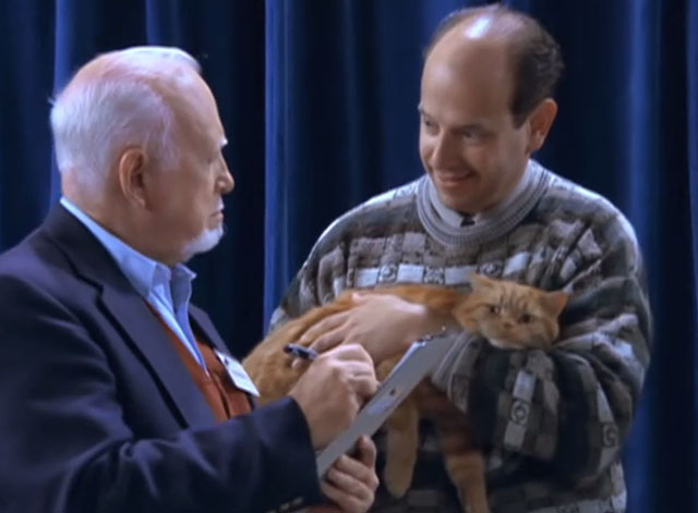 Just Shoot Me! - A Divorce to Remember - man holding ginger tabby cat for cat show judge