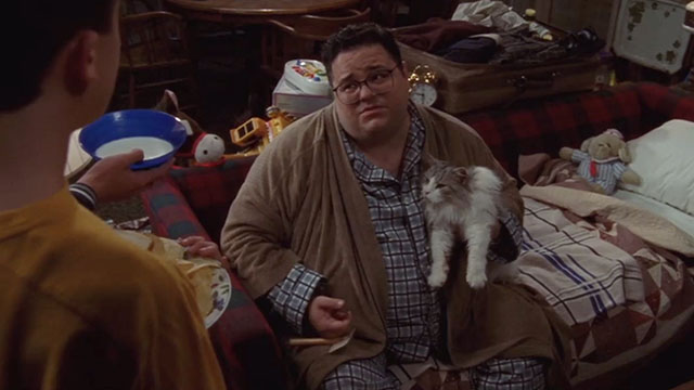 Malcolm in the Middle - Malcolm vs. Reese - Craig David Anthony Higgins holding longhair grey and white cat Jellybean on couch