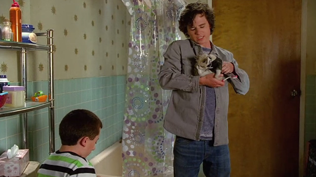 The Middle - From Orson with Love - Brick Atticus Shaffer with Axl Charlie McDermott holding Siamese mix kitten as James Bond in bathroom