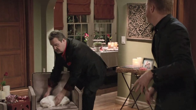 Modern Family - Heart Broken - Larry Frosty cat being picked up from chair by Cameron Eric Stonestreet with Mitchell Jesse Tyler Ferguson