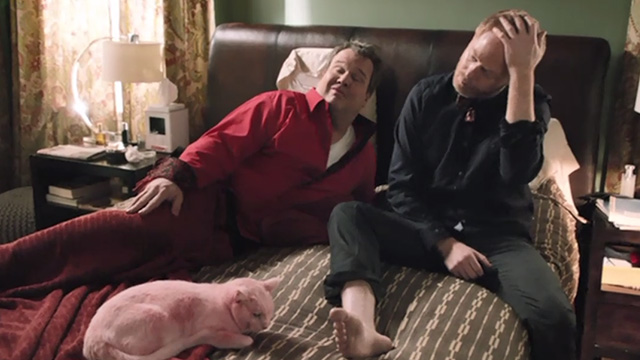 Modern Family - Heart Broken - Cameron Eric Stonestreet and Mitchell Jesse Tyler Ferguson in bed looking at pink Larry Frosty cat