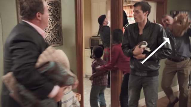 Modern Family - Larry's Wife - man grabbing up orange tabby cat amidst chaos