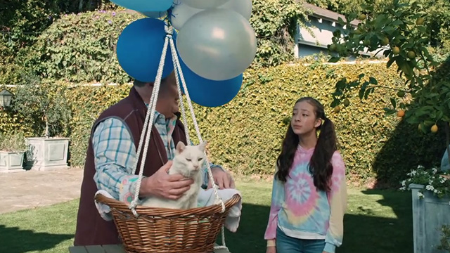 Modern Family - I'm Going to Miss This - Cameron Eric Stonestreet with white cat Larry Frosty in basket tied to balloons and Lily Aubrey Anderson-Emmons