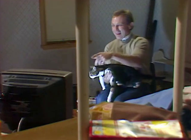 Rafferty's Rules - Unaired Pilot - Rafferty Chris Haywood holding calico tabby cat while watching television