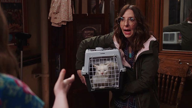 Superstore - Sandra's Wedding - Carol Irene White holding cat Biscuit carrier