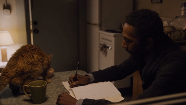 This is Us - Clooney - orange tabby cat Clooney with bent ear eating on table as William Ron Cephas Jones writes