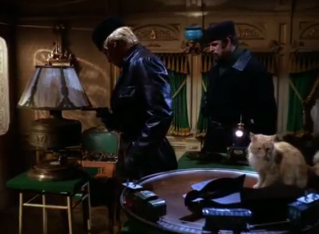 The Wild Wild West - The Night of the Big Blackmail - bad guy throws down figure with longhaired ginger tabby cat on table
