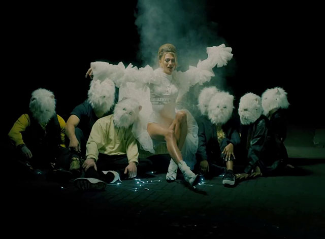 Remedy - Leony surrounded by men wearing white Persian cat heads